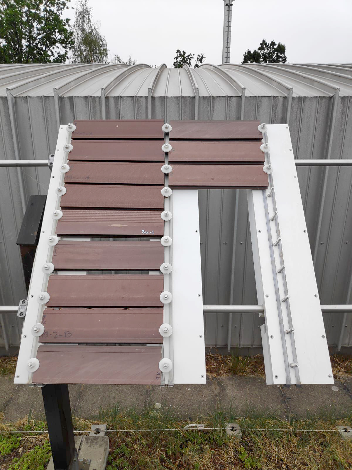 Kleine Anlage zur Freibewitterung auf einem Hausdach, bestückt mit zwölf Profilstücken