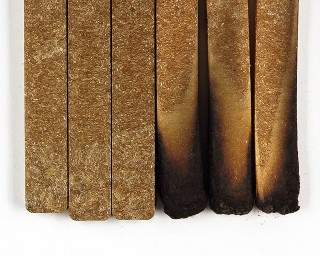 Das Foto zeigt drei WPC-Prüfstäbe ohne Brandspuren und drei WPC-Prüfstäbe mit Brandspuren.