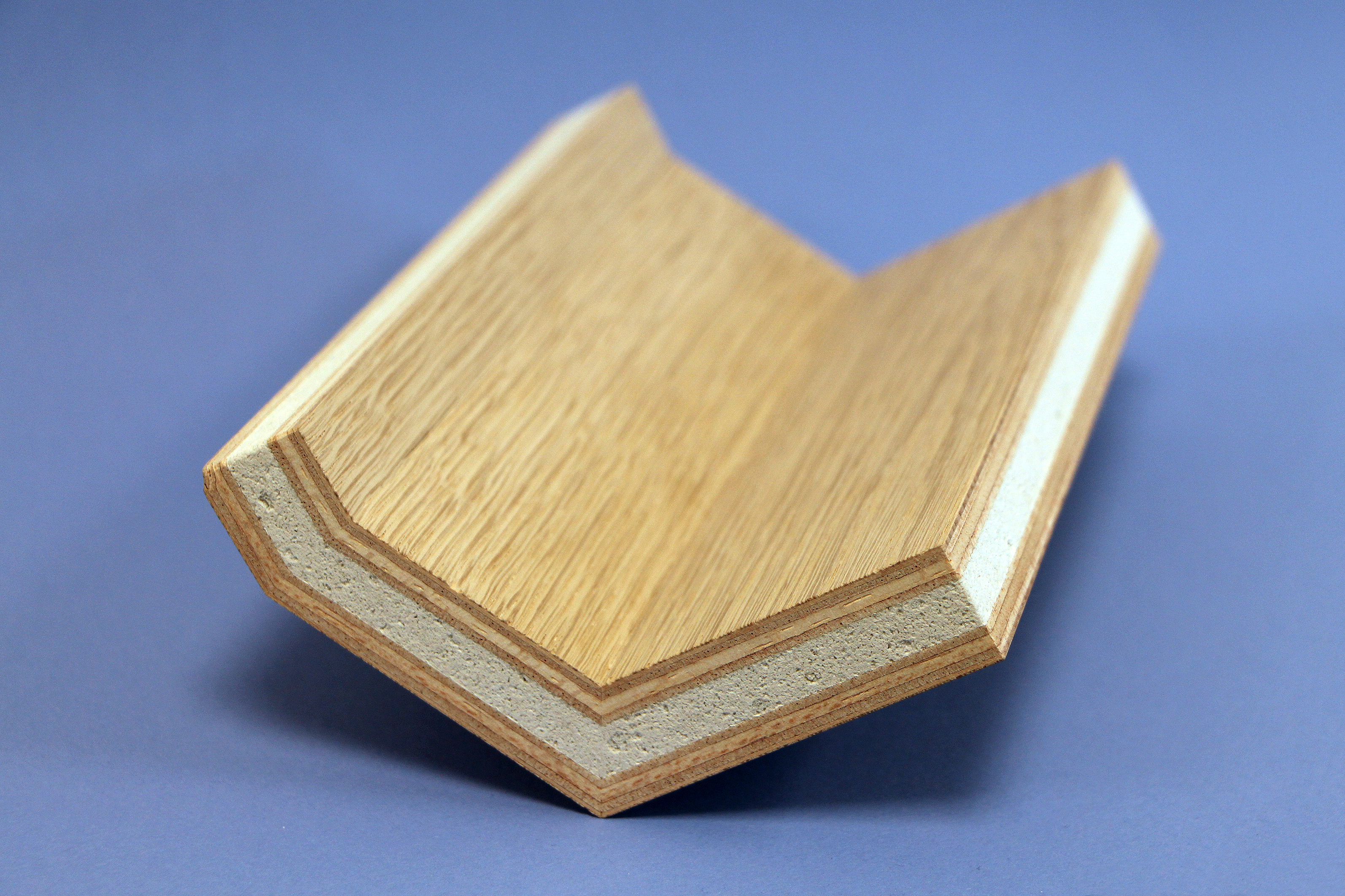 Zu sehen ist ein kleines Formteil. Die hybride Sperrholzplatte ist zweifach abgewinkelt; der Blähglaskern ist durchgehend.