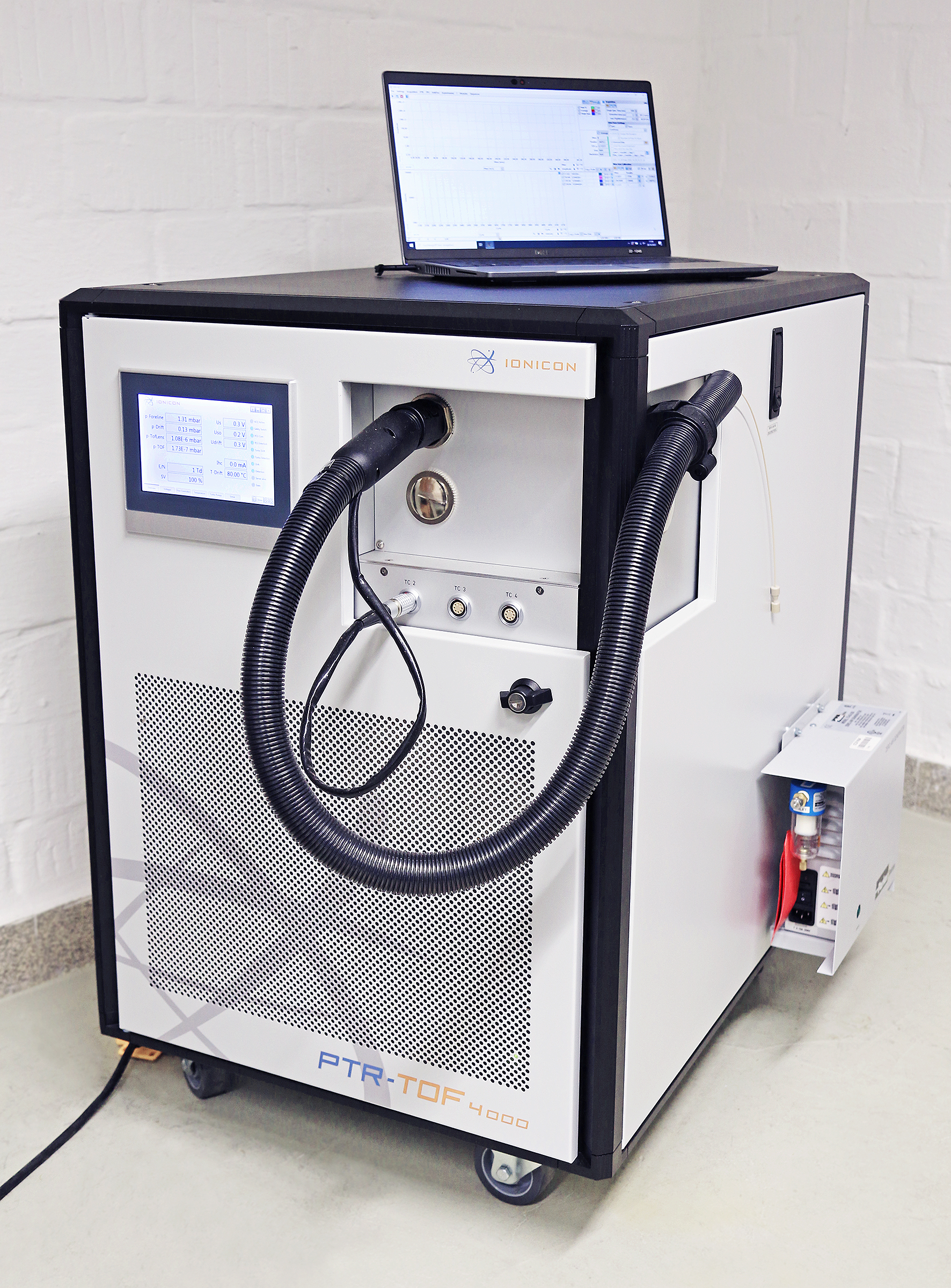 Protontransferreaktions-Time-Of-Flight-Massenspektrometer (PTR-TOF-MS) Das Foto zeigt ein quaderförmiges, etwa 90 cm hohes Laborgerät auf Rollen. Es hat seitlich ein Display und verschiedene Anschlüsse für Schläuche. Auf der geschlossenen Oberseite des Geräts steht ein Laptop.
