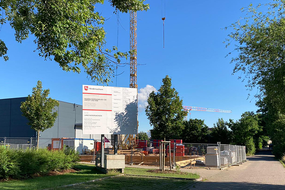 The image shows the building site with site fence and crane at the Fraunhofer WKI location in Hanover.