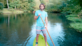 Christoph Pöhler standing on a stand-up paddleboard on the Oker river.