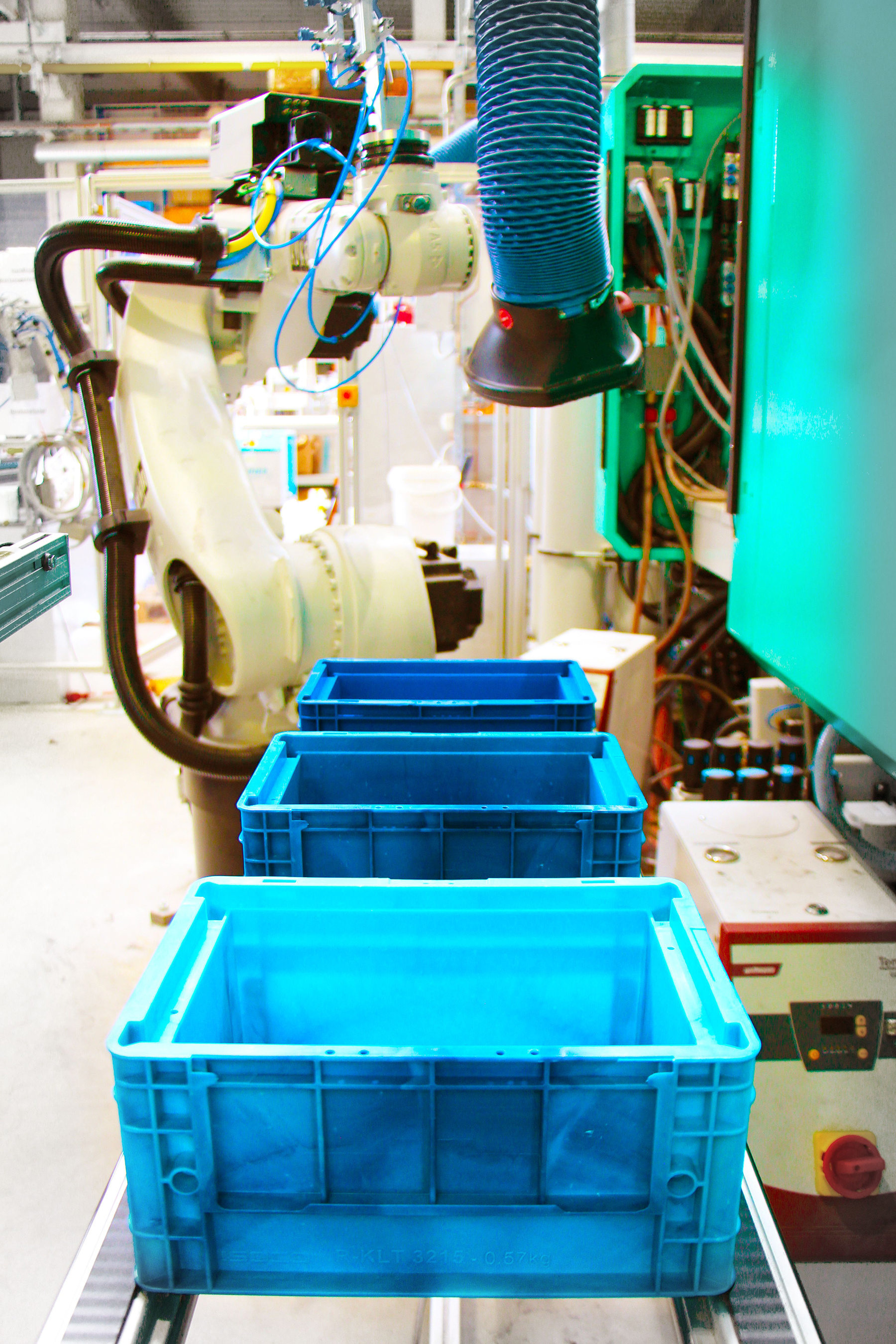 The photo shows three new transport boxes on a conveyor belt.