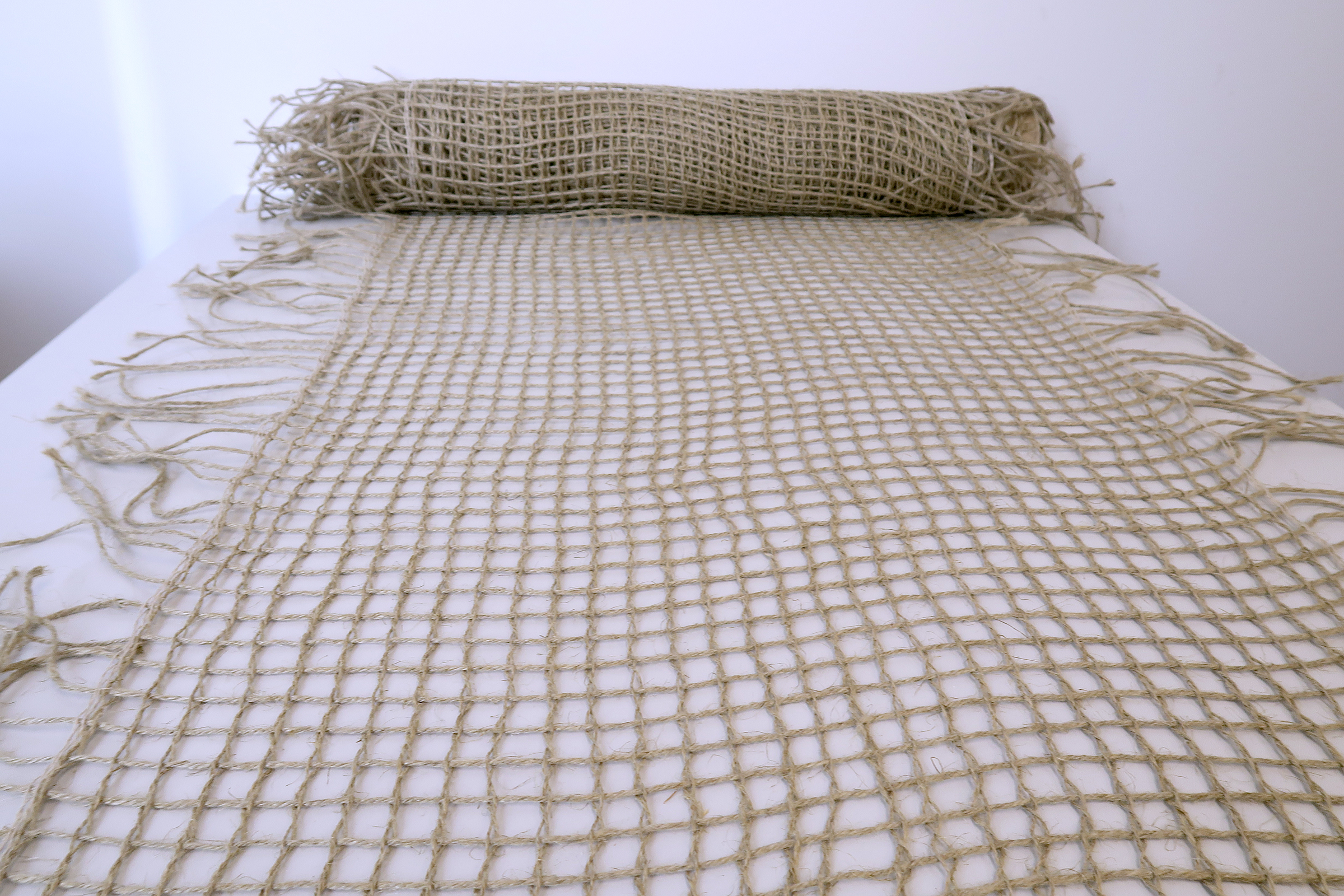 The photo shows a latticed flax fabric lying on a table.