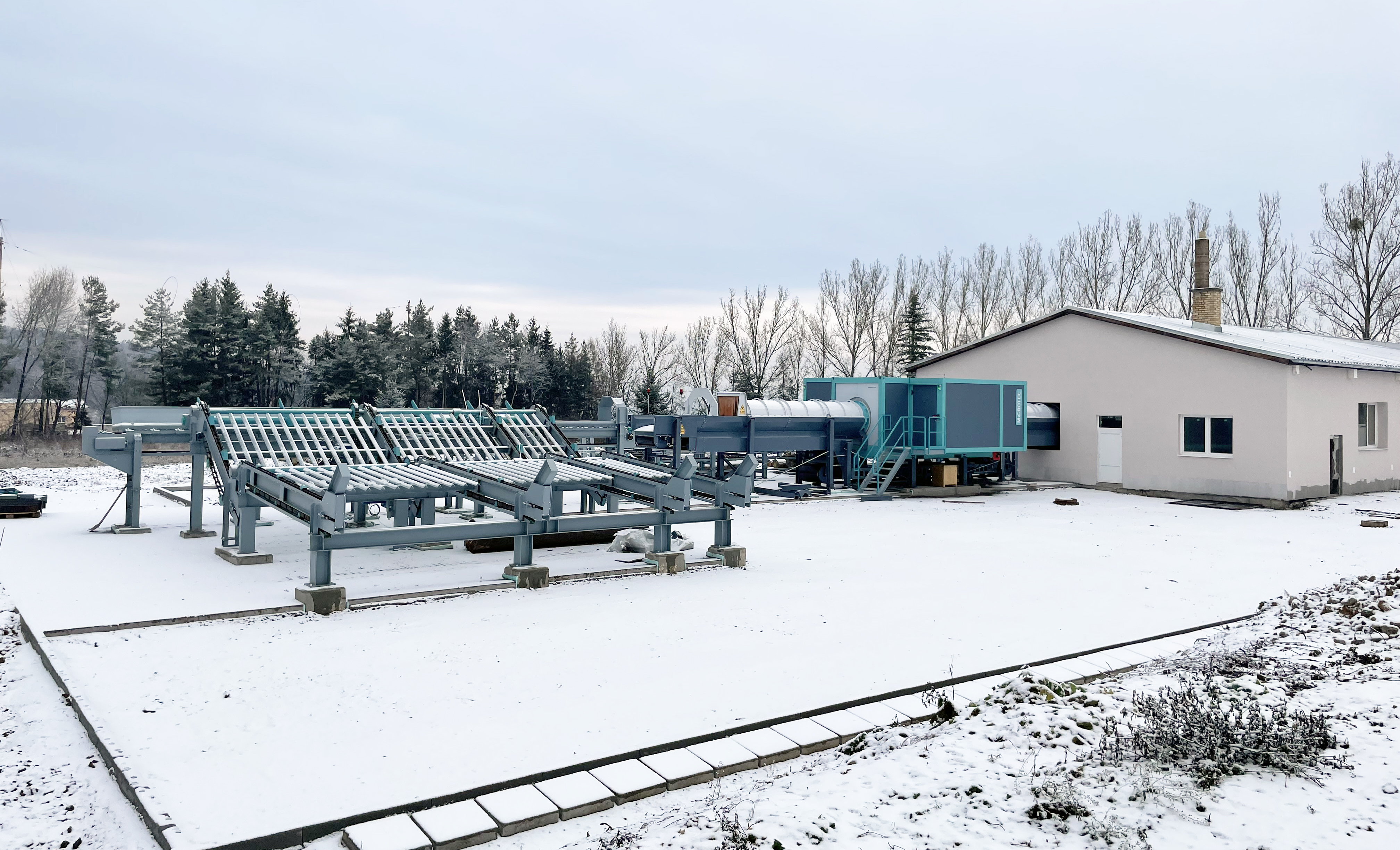 The photo shows an outdoor area next to a building with a machine.