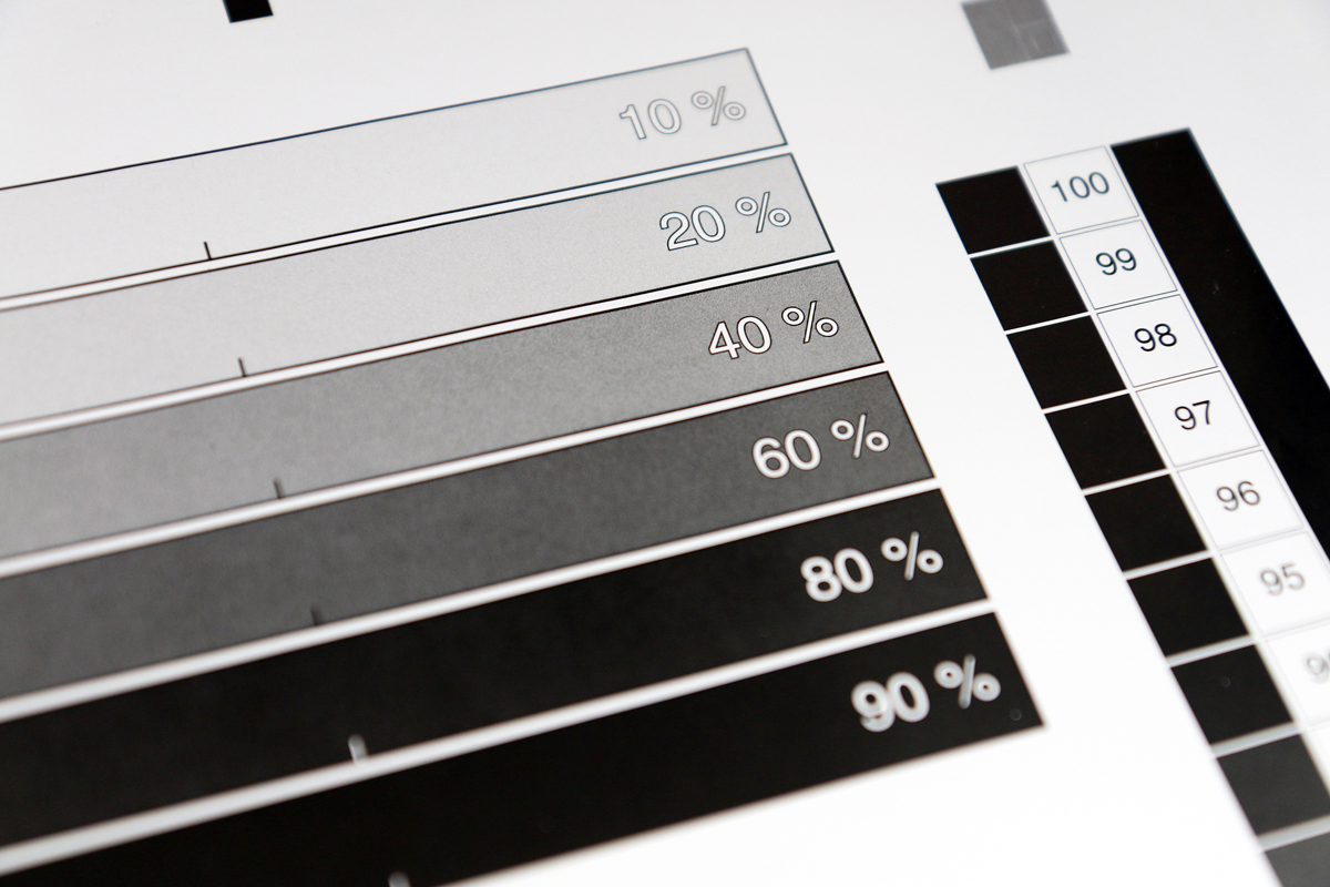 Section of paper with printed test strips in different brightness levels from white through to black. 