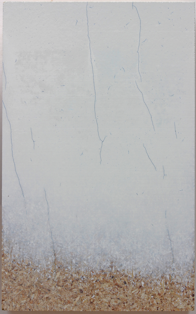 View from above of a piece of OSB board partially covered by a white layer which becomes thinner from right to left. Dark, irregular lines can be seen in the white layer.