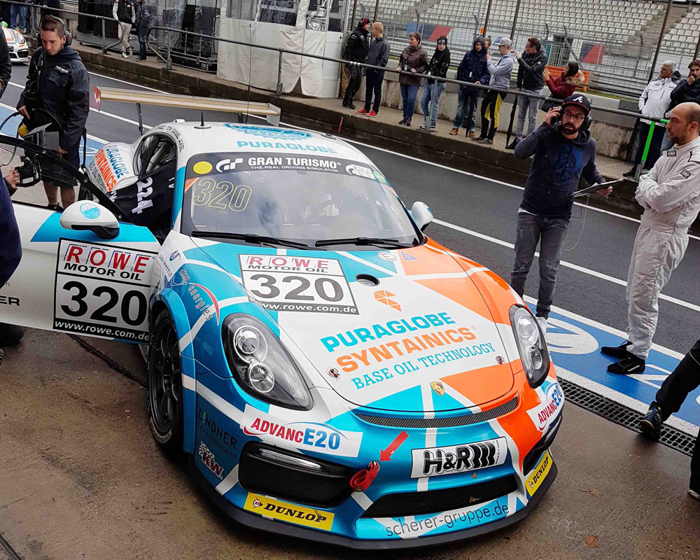 Porsche racing car with open passenger door in the pit-stop area of the Nürburgring. 