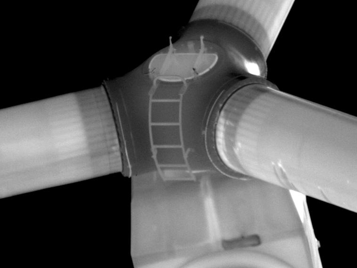 Black-and-white image of the hub of a wind turbine.