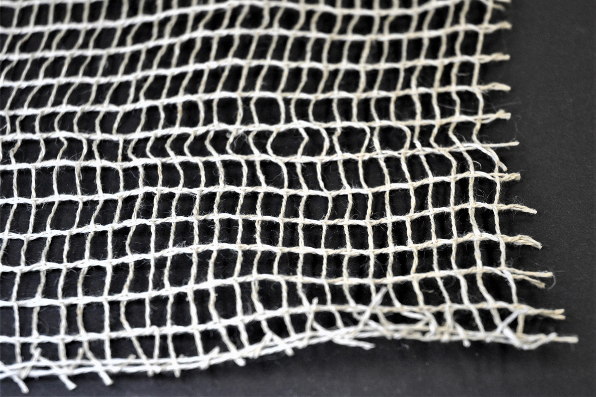 Open-weave sacking-type fabric with light-colored threads.
