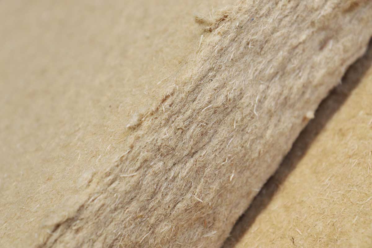 The photo shows the surface and cut edge of a wood-fiber insulation board.
