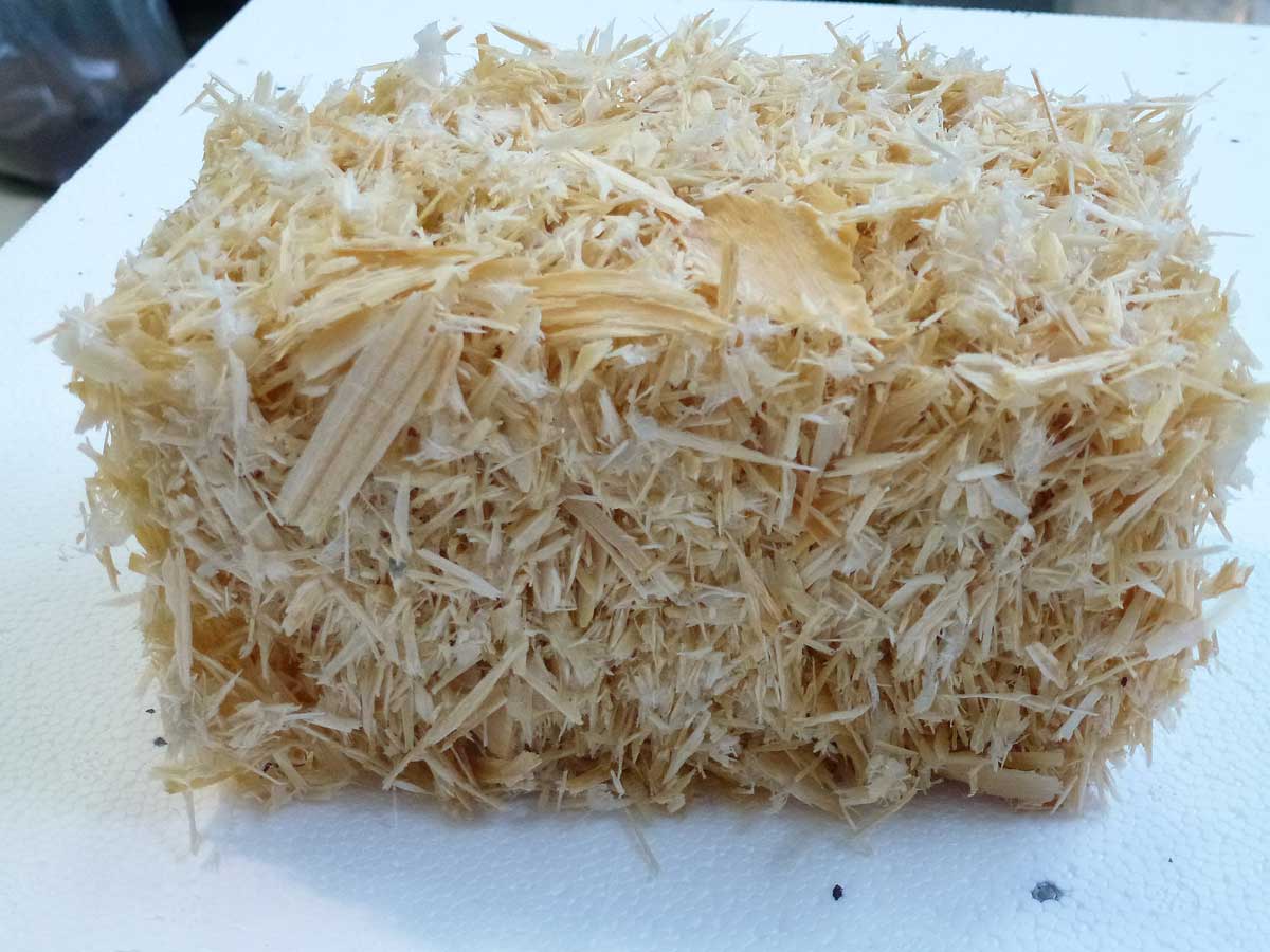 The photo shows a cuboid body consisting of an airy but stable mixture of wood shavings of varying sizes.