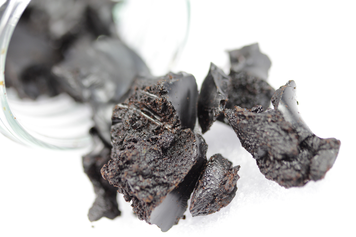 Dried lignin sulfonate The photo shows black-brown, clay-like lumps.