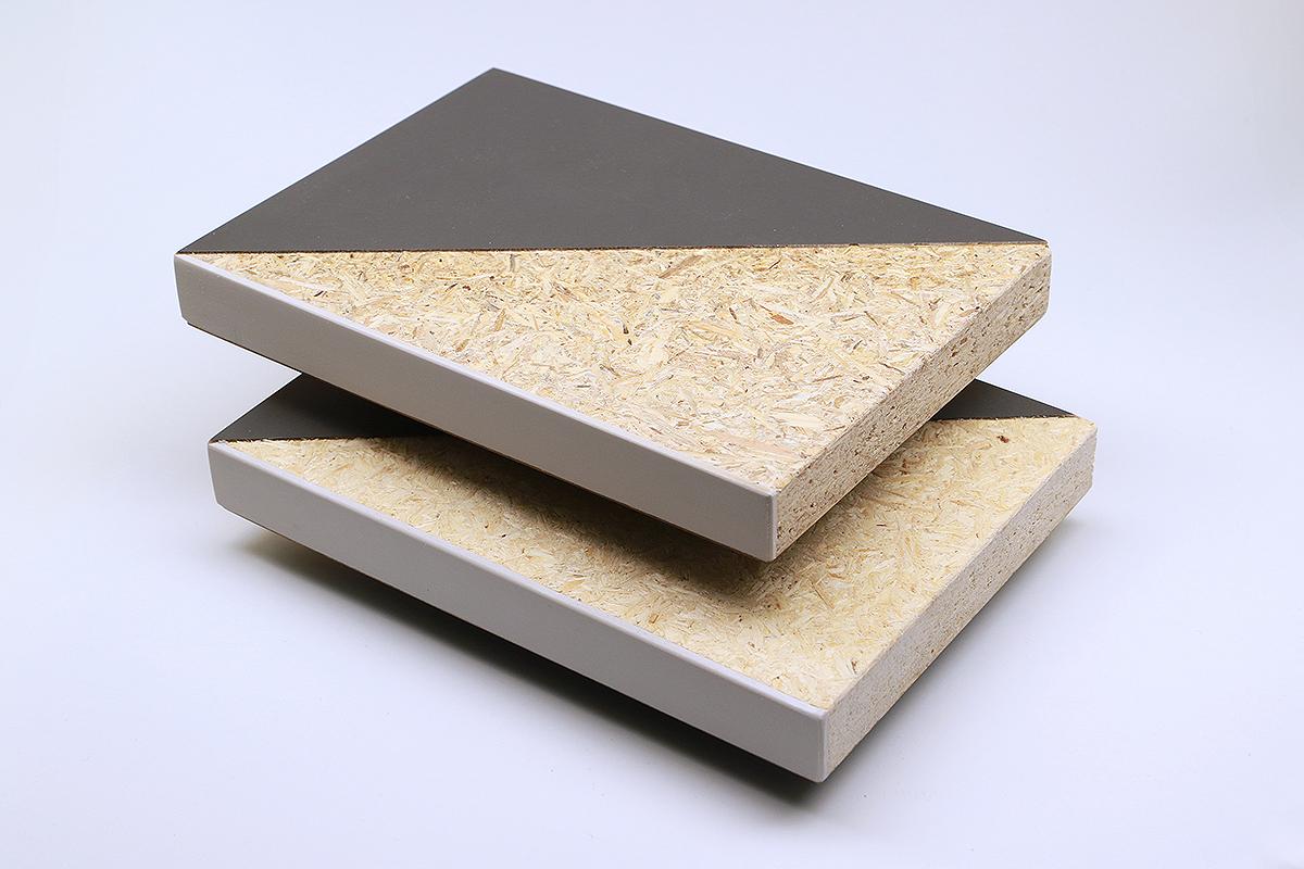 Partially coated particle board pieces made from waste wood and fresh wood The photo shows two partially coated pieces of particle board that look almost identical. Some of the wood chips on the upper board are slightly darker.